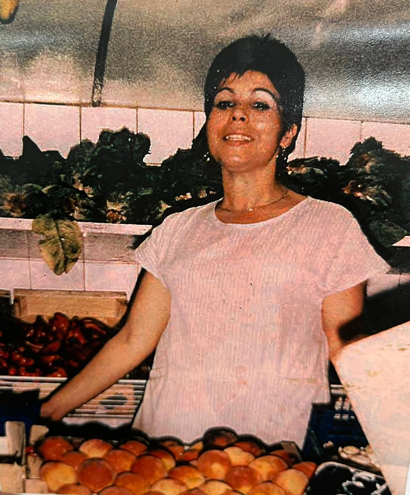 Fotografia històrica d’una paradista envoltada de fruita i verdura