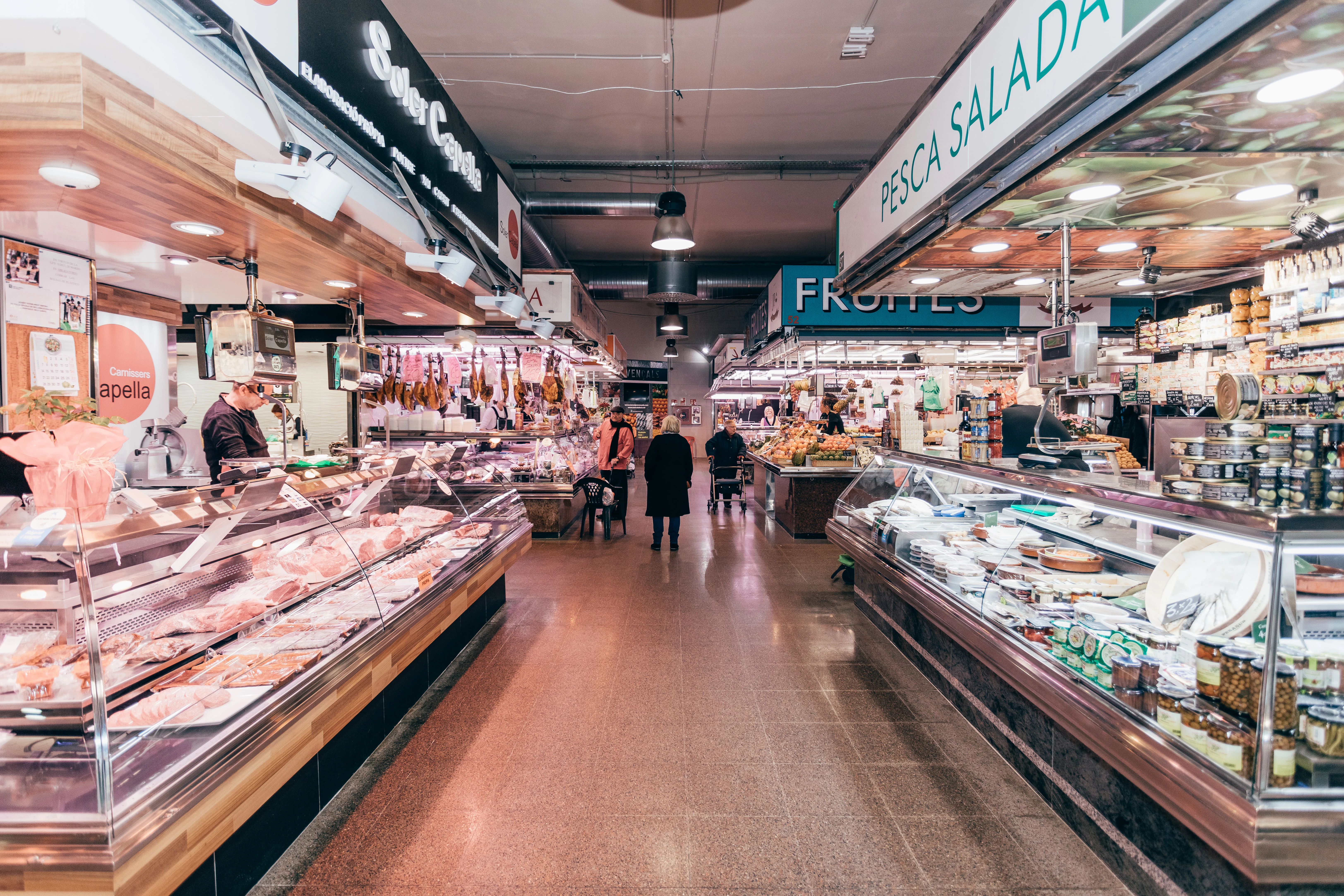 Soler Capella a l’esquerra del passadís del Mercat de Provençals, amb paradistes i clients